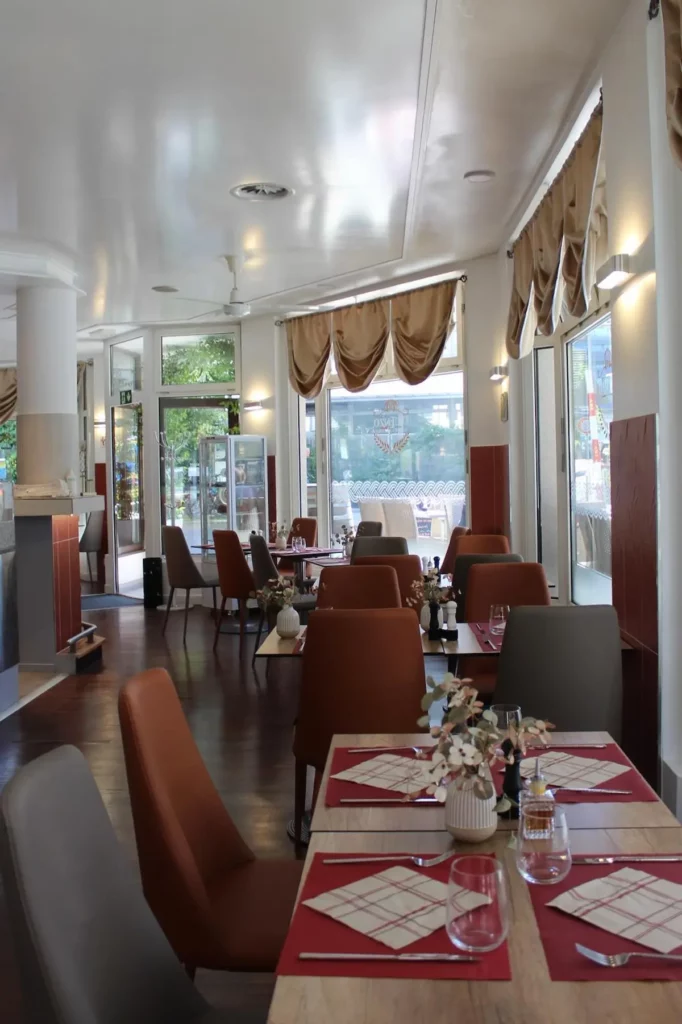 Salle intérieure du restaurant Da Enzo à Genève avec tables dressées et ambiance italienne.
